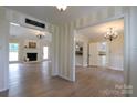 Open-concept living room featuring hardwood floors, fireplace, and views into the kitchen and other rooms at 8829 Gelligum Dr, Charlotte, NC 28277