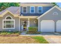 Inviting entrance with a glass front door, manicured shrubs, and a two-car garage at 8909 Elkins Park Dr, Matthews, NC 28105