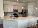 Modern kitchen featuring stainless steel appliances and a large kitchen island with countertop seating at 11608 Founders Park Ln, Pineville, NC 28134