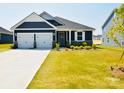 Charming home featuring a two-car garage, beautiful gray siding, and well-manicured lawn, creating great curb appeal at 12209 Riceland Way, Midland, NC 28107