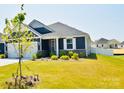 Charming home featuring a two-car garage, beautiful gray siding, and well-manicured lawn, creating great curb appeal at 12209 Riceland Way, Midland, NC 28107