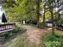 Secluded backyard featuring a deck, storage sheds, and mature trees offering privacy at 12623 Levins Hall Rd, Huntersville, NC 28078