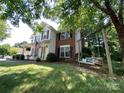 Charming two-story home with a front porch, swing and well-manicured landscaping at 12623 Levins Hall Rd, Huntersville, NC 28078