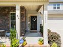 Inviting front porch features stone accents, elegant columns, and a decorative wreath on the front door at 15211 Colonial Park Dr, Huntersville, NC 28078