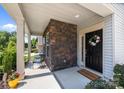Charming front porch adorned with a seasonal wreath, stone accents, and ample space for seating at 15211 Colonial Park Dr, Huntersville, NC 28078
