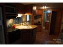 The RV kitchen features a sink, gas range, microwave, and ample cabinet space at 155 Holly Harbor Trl, Mount Gilead, NC 27306