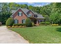 Lovely brick home boasting a lush green lawn and mature landscaping at 18800 Boundary Oaks Ct, Davidson, NC 28036