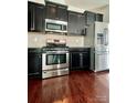 Modern kitchen with stainless steel appliances, black cabinetry, and hardwood floors at 2769 Sawbridge Ln, Gastonia, NC 28056