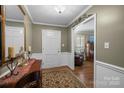 Elegant home entryway featuring hardwood floors, a decorative rug, and classic wainscoting, leading into the living spaces at 5006 Crooked Oak Ln, Charlotte, NC 28226