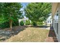 A tranquil backyard setting with mature trees, a well-kept lawn, and a cozy patio area at 7406 Carolina Jessamine Ct, Indian Land, SC 29707