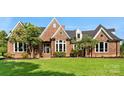 Charming brick home showcasing well-manicured lawn and inviting front entrance with detailed trim at 929 Blacksnake Rd, Stanley, NC 28164