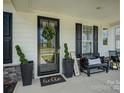 Inviting front porch with seating, plants, and a welcoming 'hello' doormat at 9507 Pointer Rd, Huntersville, NC 28078