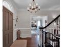 Inviting entryway boasts hardwood floors, wainscoting, and chandelier at 10500 Kilmory Ter, Charlotte, NC 28210