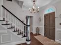 Spacious entryway with hardwood floors, staircase, and stylish chandelier at 10500 Kilmory Ter, Charlotte, NC 28210