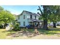 Two-story home with a covered front porch, a fenced yard, and mature landscaping at 164 N Eastway Dr, Troutman, NC 28166