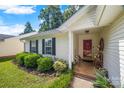 Close-up of a home's welcoming porch with a red door and decorated seating area at 1668 Tate Rd, Rock Hill, SC 29732