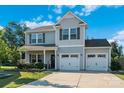 Beautiful two-story home boasts a well-maintained lawn, a two-car garage, and charming gray siding at 210 Clove Hitch Dr, Statesville, NC 28677