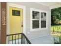 Inviting front entrance with a bright yellow door and large windows, complemented by fresh gray siding at 2732 Mayfair Ave, Charlotte, NC 28208