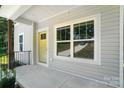Covered porch featuring a yellow front door and large windows that provide plenty of natural light at 2732 Mayfair Ave, Charlotte, NC 28208