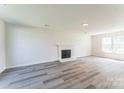 Bright living room featuring modern fireplace, grey floors and a large window providing natural light at 3702 Arthur St, Indian Trail, NC 28079