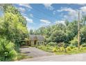 Cute home featuring a carport, vibrant garden, and a peaceful atmosphere surrounded by nature at 4124 Oakwood Rd, Charlotte, NC 28269