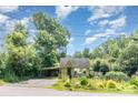 Inviting home with colorful flower garden, carport, and ample greenery providing a private setting at 4124 Oakwood Rd, Charlotte, NC 28269