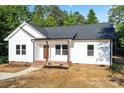 Charming single-story home features a white exterior, brick foundation, and a welcoming front porch at 5328 Oaktree Dr, Gastonia, NC 28052