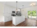 Modern kitchen with white cabinets, stainless steel appliances, and island with sink, offers backyard views at 5328 Oaktree Dr, Gastonia, NC 28052