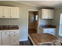 Updated kitchen with modern countertops, white cabinets, and a view of the adjacent room at 6218 Old Pageland Marshville Rd, Marshville, NC 28103