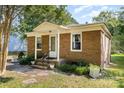 Inviting brick home with a quaint covered porch, tidy landscaping, and classic curb appeal at 6616 Woodlawn Ln, Indian Trail, NC 28079