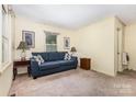 Cozy living room featuring a comfortable blue sofa, neutral walls, and ample natural light at 6616 Woodlawn Ln, Indian Trail, NC 28079