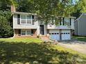 Charming two-story home with an attached two-car garage and a well-maintained lawn at 707 Regency Dr, Charlotte, NC 28211