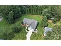 Beautiful aerial view of a well-maintained home with lush green lawn, long drive, and mature trees surrounding the property at 8275 Normandy Rd, Denver, NC 28037