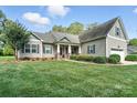 Beautiful home featuring a well-manicured lawn, covered front porch with columns, and attached garage, creating curb appeal at 8275 Normandy Rd, Denver, NC 28037