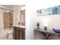 Cozy bathroom featuring a shower-tub combo, a dark wood vanity, and neutral tile at 10240 Superb Ln, Charlotte, NC 28215