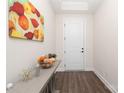 Bright foyer with wood floors, a decorative console table, and an inviting white front door at 10240 Superb Ln, Charlotte, NC 28215