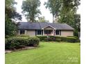 Inviting one-story home with a lush front lawn and meticulously trimmed hedges at 1047 Honeybee Trl, Fort Mill, SC 29715