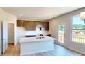 Modern kitchen with an island, ample cabinet space, stainless steel sink, and exterior door to deck at 11017 Warfield Ave # 4, Huntersville, NC 28078