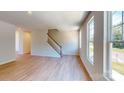 Open-concept living room featuring hardwood floors, a staircase, and an abundance of natural light at 11017 Warfield Ave # 4, Huntersville, NC 28078