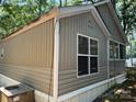 The exterior of the home featuring neutral siding and white-framed windows in a wooded neighborhood at 111/113 Shawnee Trl # D140/141, Mount Gilead, NC 27306
