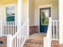 A covered front porch with brick accents and a black front door provides a welcoming entrance at 1542 Antioch Dr, Conover, NC 28613