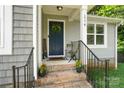 Inviting front porch features brick steps, a navy door with wreath, and seasonal flower pots at 1774 Timmons Marie Ln, Lincolnton, NC 28092