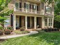 Inviting front porch with classic columns, rocking chairs, and beautiful landscaping at 2103 Lytton Ln, Matthews, NC 28104
