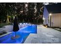 Backyard pool featuring illuminated fountains, in-pool seating, and a patio area perfect for relaxing and entertaining guests at 2418 Shuford Rd, Lincolnton, NC 28092