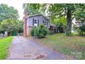 View of the home with a side driveway and mature trees providing shade at 5008 Brooktree Dr, Charlotte, NC 28208