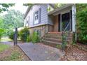 The front porch area is elevated with brick steps and a black iron railing at 5008 Brooktree Dr, Charlotte, NC 28208