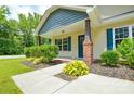 Welcoming front entrance with a well-manicured landscape, brick supports and blue shutters at 551 Sylvan Sw St, Concord, NC 28025
