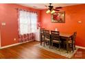 Cozy dining area featuring wood table, chairs, modern ceiling fan, and bright window with floral curtains at 7333 Rosehall Dr, Charlotte, NC 28227