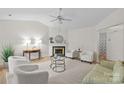 Bright living room with vaulted ceilings, fireplace, neutral decor, and wood-look floors at 9136 Four Mile Creek Rd, Charlotte, NC 28277