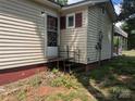Exterior corner of home with cream siding and a small set of stairs leading to the back door at 1110 Sulfur Springs Church Rd, Shelby, NC 28152